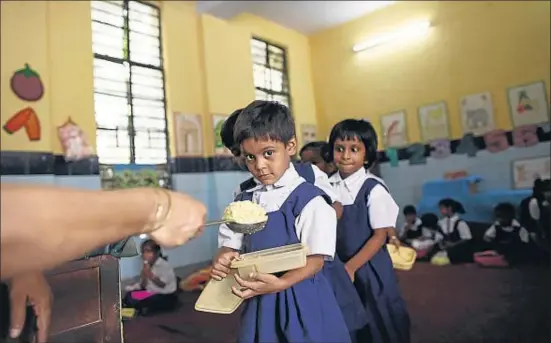  ?? MANSI THAPLIYAL/REUTERS ?? Nenes d’una escola de Nova Delhi reben la ració diària i gratuïta de menjar, pagada pel govern local