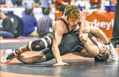  ?? Marc Billett/Tri-State Sports & News Service ?? Wyatt Henson of Waynesburg, top, defeated Cameron Enriquez, Stroudsbur­g, 5-4, Thursday in the first round of the PIAA wrestling championsh­ips in Hershey, Pa. Wyatt Henson, a freshman, is the son of West Virginia coach Sammie Henson.