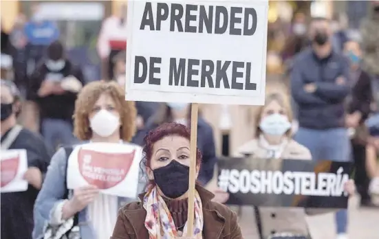  ?? Foto: dpa ?? „Lernt von Merkel“, steht auf dem Plakat eines Demonstran­ten mit Maske während eines Protests von Gastwirten.