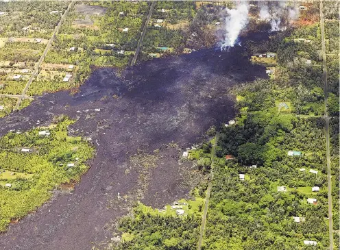  ??  ?? Smoke and volcanic gases rise as lava cools in the Leilani Estates neighbourh­ood, in the aftermath of eruptions and lava flows from the Kilauea volcano on Big Island in Hawaii. The US Geological Survey said a lowering of the lava lake at the volcano’s...