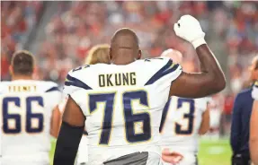  ?? MARK J. REBILAS/USA TODAY SPORTS ?? The Chargers’ Russell Okung raised his fist during the national anthem before Saturday’s game against the Cardinals.