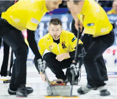  ??  ?? Skip Mike McEwen from Winnipeg watches his rock as second Matt Wozniak, left, and lead Denni Neufeld sweep during Olympic curling trials action against Team Koe on Tuesday in Ottawa. ADRIAN WYLD / THE CANADIAN PRESS