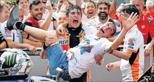  ??  ?? Marc Márquez celebra con su equipo y con su hermano, al que sostiene, su remontada hasta el segundo puesto en Sepang y el título de Álex.
