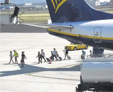  ?? ÁNGEL DE CASTRO ?? Viajeros desembarca­ndo de un avión de la compañia Ryanair en el aeropuerto de Zaragoza.