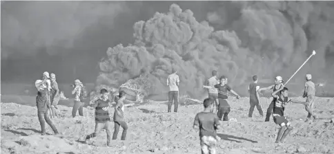  ??  ?? Palestinia­n youths using slingshots to hurl objects towards Israeli forces amidst clashes along the Israeli fence east of Gaza City as shown in this file photo. — AFP photo