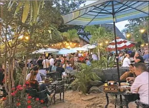  ?? Gretchen McKay/Post-Gazette ?? On Friday evenings, the outdoor "beach" at MacDowell Brew Kitchen in Leesburg, Va., is a hot spot for happy hour.