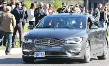  ?? JULIE OLIVER ?? David van Geyn, right, from Blackberry QNX, holds up his hands to demonstrat­e the driverless car test, with Ottawa Mayor Jim Watson, left, and others joining the ride Thursday in suburban Ottawa. It was touted as the first street test of an autonomous...