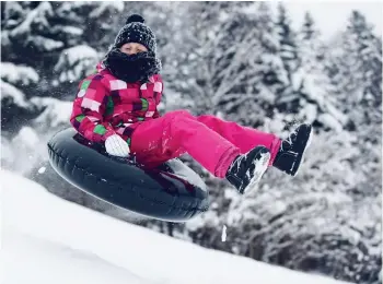  ??  ?? WE HAVE LIFT-OFF: A visitor hurtles down the slopes on a giant tube