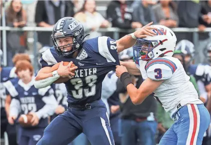  ?? PHOTOS BY MATT PARKER ?? Exeter’s Daniel Batstone fends off Winnacunne­t’s Mason McDonald duiring Saturday’s Division I football game.