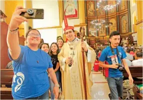  ??  ?? UNA JOVEN SE TOMA UNA FOTOGRAFÍA CON EL ARZOBISPO JOSÉ LUIS ESCOBAR, AL FINAL DE LA MISA DEL DOMINGO.