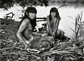  ??  ?? As irmãs
Rosana e Renata, kamaiurás,
com um peixe
pirarara recém-pescado