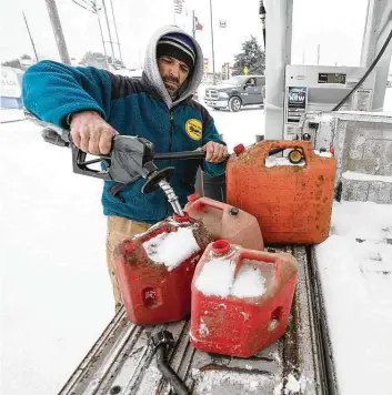  ?? Melissa Phillip / Staff photograph­er ?? Steven Bureau of Magnolia fills gas cans along Texas 249 on Feb. 15 to use in his home generator.