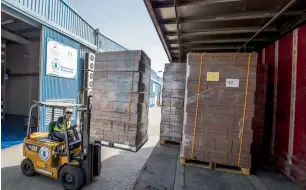  ?? Photo by Leslie Pableo ?? A worker loads food for Somalia into containers at the World Food Programme Warehouse at Internatio­nal Humanitari­an City in Dubai on Wednesday. —