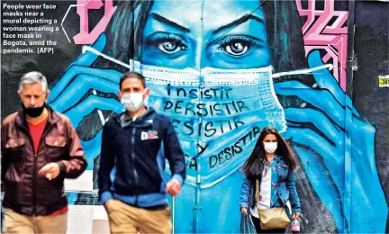  ??  ?? People wear face masks near a mural depicting a woman wearing a face mask in Bogota, amid the pandemic. (AFP)
