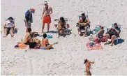  ?? ANDREW MILLS/NJ ADVANCE MEDIA ?? New Jersey Gov. Chris Christie, right, on the beach Sunday with family and friends at the governor’s summer house. Public beaches closed due to a budget impasse.