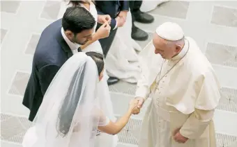  ??  ?? El papa saluda a una pareja de recién casados ayer en la audiencia general vaticana.