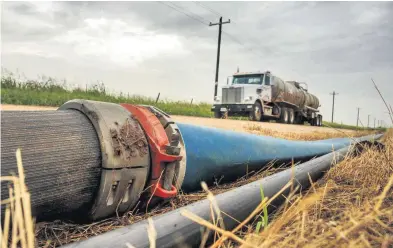  ?? [OKLAHOMAN ARCHIVES PHOTO] ?? Temporary lines used to pump water to oil and natural gas well sites are shown in a Kingfisher road’s right of way earlier this year.