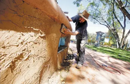  ?? PHOTOS BY LUIS SÁNCHEZ SATURNO THE NEW MEXICAN ?? LEFT: Francisco Ochoa of Santa Fe re-stuccos a wall Thursday at the Santa Fe Children’s Museum. After facing an uncertain future, the museum is now on solid footing and is looking to grow.
