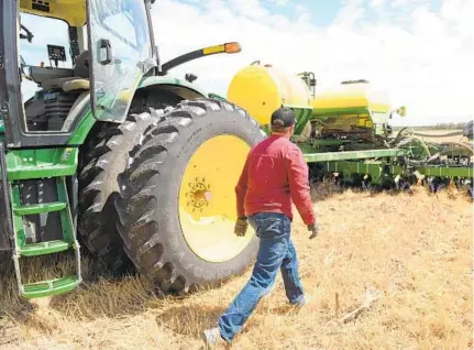  ?? JERRY JACKSON/BALTIMORE SUN PHOTOS ?? Jason Scott checks on a seed jam while planting in a Dorchester County field. Scott, a sixth-generation farmer, is concerned about how potential Chinese tariffs on U.S. soybeans may affect his business.