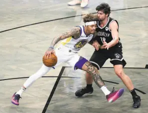  ?? Sarah Stier / Getty Images ?? The Warriors’ Kelly Oubre Jr. tries to drive past the Nets’ Joe Harris in the first half. Oubre, acquired to fill some of the gaps left by Klay Thompson, scored six points.