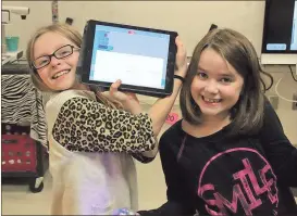  ?? Spencer Lahr / RN-T ?? East Central Elementary third-graders Annabelle Turner (right) and Delilah Beaston are all smiles after getting their Sphero, a spherical robot, to travel a perfect square.