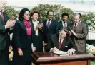 ?? ?? Ronald Reagan signs a bill in 1983 making Martin Luther King Jr’s birthday a national holiday, as Coretta Scott King looks on. Photograph: Historical/Corbis/Getty Images