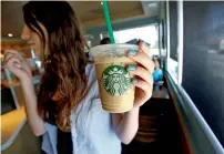  ?? Reuters file ?? A patron holds an iced beverage with a straw, at a Starbucks coffee store in Pasadena, California. —