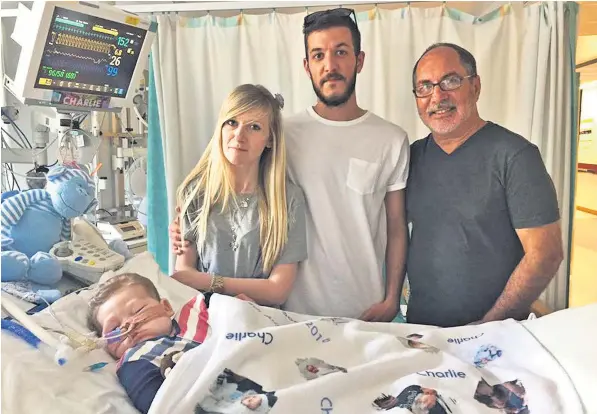  ??  ?? The Rev Patrick Mahoney posted this photograph on Facebook of himself with terminally ill baby Charlie Gard, wearing a Us-themed romper suit, and Charlie’s parents Chris Gard and Connie Yates