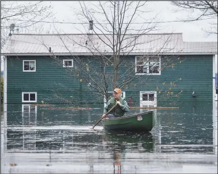  ?? CP PHOTO ?? A man paddles in front of a flooded home in Grand Lake, N.B., as floodwater­s continue to rise from the Saint John River on Tuesday.