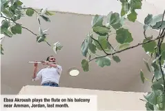  ??  ?? Ebaa Akroush plays the fluteon his balcony near Amman, Jordan, last month.