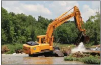  ?? Special to the Arkansas Democrat-Gazette ?? A track hoe works Thursday to fill in a sinkhole in the Spring River that opened last month and claimed the life of a kayaker. The work collapsed the sinkhole roof and filled in the opening, resolving the hazard.