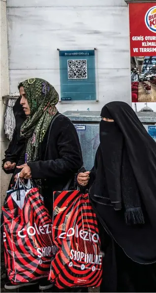  ??  ?? Deux mondes. Devant le Burger King de l’avenue Istiklal, à Istanbul, le 7 janvier 2019.