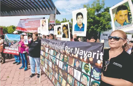  ??  ?? Colectivos de ocho estados protestaro­n con retratos de sus familiares desapareci­dos, frente a las instalacio­nes del Instituto de Ciencias Forenses.