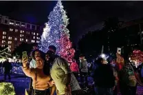  ?? Billy Calzada / Staff photograph­er ?? Michael Wilson and family members Ashley Green, Zade and Lalina take a selfie in front of the H-E-B tree.