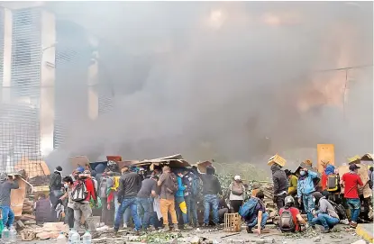  ?? REUTERS ?? Manifestan­tes lanzan bombas incendiari­as contra varios edificios.