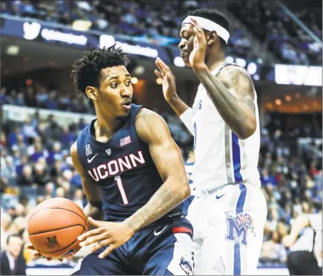  ?? Brad Vest / Associated Press ?? UConn’s Christian Vital, left, works for position against Memphis’ Kyvon Davenport on Sunday.