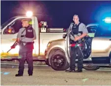  ?? JOHN SPINK/ATLANTA JOURNAL-CONSTITUTI­ON VIA AP ?? Police officers stand at the scene following a police chase Monday in Carroll County, Ga.