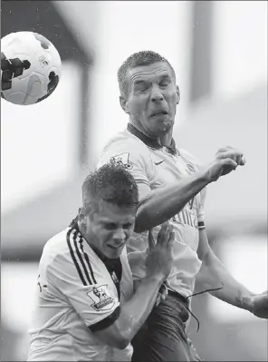  ?? CARL COURT / AGENCE FRANCE-PRESSE ?? Arsenal striker Lukas Podolski (right) battles with Fulham midfielder Alexander Kacaniklic during the English Premier League match at Craven Cottage in London on Saturday. Arsenal won 3-1.