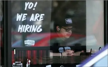  ?? NAM Y. HUH — THE ASSOCIATED PRESS FILE ?? A hiring sign is displayed at a restaurant in Schaumburg, Ill., April 1. The white-hot demand for U.S. workers cooled a bit in April, though the number of unfilled jobs remains high and companies are still desperate to hire more people. Employers advertised 11.4million jobs at the end of April, the Labor Department said June 1, down from nearly 11.9million in March, the highest level on records that date back 20years.