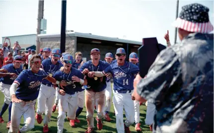  ?? SARAH PHIPPS/THE OKLAHOMAN ?? Silo players race toward the state championsh­ip trophy after beating Oktaha for the Class 2A baseball title Saturday in Shawnee.