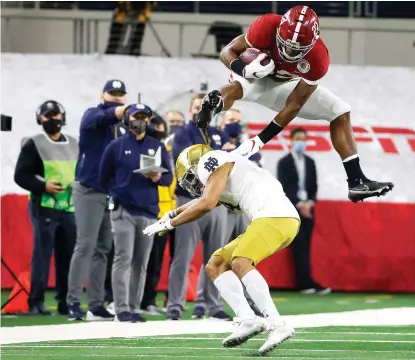  ?? AP Photo/Michael Ainsworth ?? ■ Alabama running back Najee Harris (22) hurdles Notre Dame cornerback Nick McCloud (4) as he carries the ball for a long gain in the first half of the Rose Bowl NCAA football game Friday in Arlington, Texas.