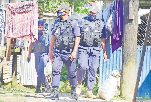  ?? Picture: SOPHIE RALULU ?? Police officers search for youths who were part of a brawl at Jittu Estate, Raiwaqa.