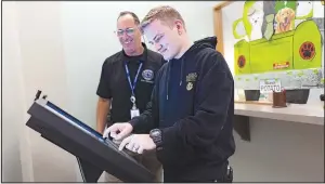  ?? (NWA Democrat-Gazette/Charlie Kaijo) ?? Jordan Karleskint (right) uses a public digital kiosk Friday alongside Gary Yarno, Benton County Fire Marshal, at the Benton County Administra­tion Building Safety Department office in Bentonvill­e. One of the improvemen­ts officials discussed during a recent Committee of Whole meeting was a public digital kiosk the department installed at its office during the first week of March. Visit nwaonline.com/ photos for today’s photo gallery.