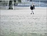  ?? PHOTO: GERARD O’BRIEN ?? Crunch time . . . A woman walks on frost in the Gardens Ground in North Dunedin yesterday.