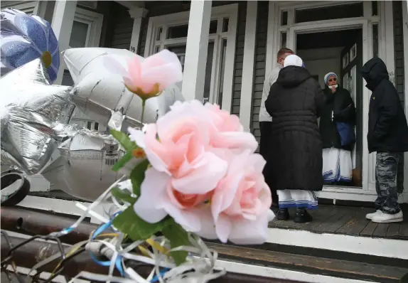  ?? NAncy lAn pHoToSE / HErAld STAFF ?? SOMBER AFTERMATH: Visitors offer condolence­s at the home of Delois Brown, who was shot dead while sitting on her front porch Saturday. Below, a man adds plastic pinwheels to the growing memorial outside the home.