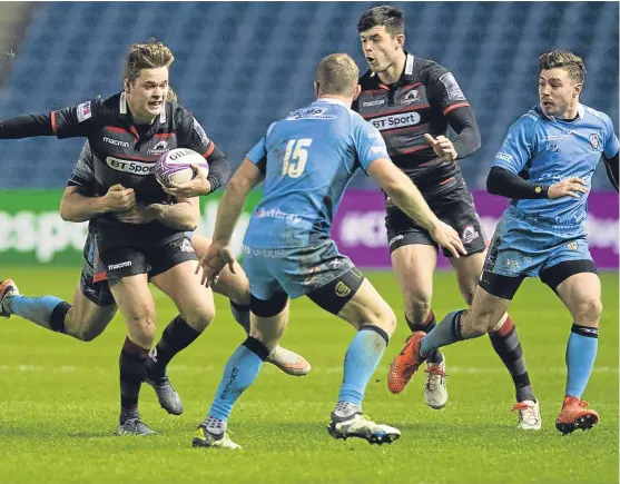  ?? Picture: SNS. ?? Edinburgh’s Chris Dean is tackled by Tom Fowlie as Richard Cockerill’s men cruise past visitors London Irish at Murrayfiel­d.