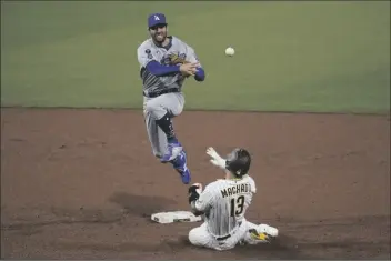  ?? GREGORY BULL/AP ?? LOS ANGELES DODGERS SECOND BASEMAN CHRIS TAYLOR throws to first for the double play as San Diego Padres’ Manny Machado (13) slides in late to second during the sixth inning of a game Saturday in San Diego.