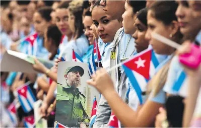  ?? RONALDO SCHEMIDT / AFP / GETTY IMAGES ?? Students await the urn with the ashes of Cuban leader Fidel Castro being driven through Cuba on Thursday.