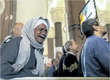  ?? SAMER ABDALLAH/THE ASSOCIATED PRESS ?? A man cries during the funeral for those killed in a Palm Sunday church attack in Alexandria, Egypt, on Monday. Islamic State suicide bombers killed at least 45 people in co-ordinated attacks on Sunday.