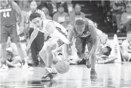  ?? MATT STAMEY/AP ?? UF guard Andrew Nembhard and Michigan State guard Cassius Winston chase a loose ball during the 10th-ranked Spartans' 63-59 win Saturday.